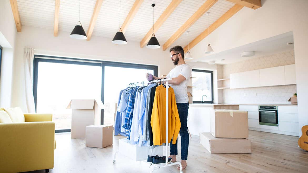 How to Pack Clothes for Moving mature man with boxes and clothes rack moving in n DQ9Q3GW 1170x658 1