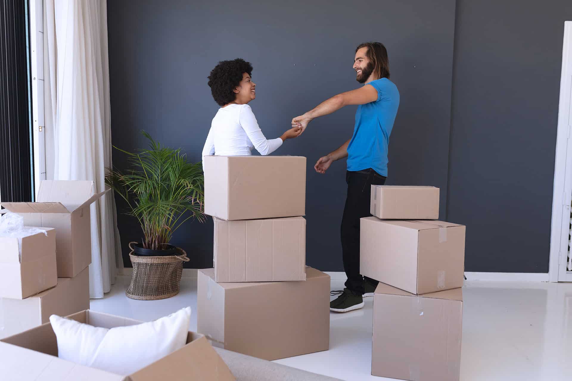 Building Stronger Neighborhoods: Why Property Managers Should Partner with Moving Companies happy diverse couple moving house smiling and danc 2023 11 27 04 57 47 utc 1